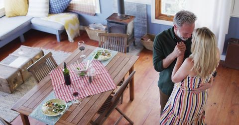 Mature Couple Embracing Joyful Dance in Cozy Living Room Setting