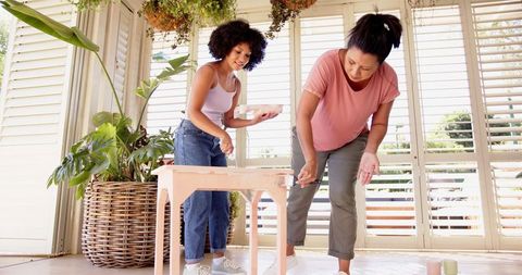 Mother and daughter bonding over diy table painting