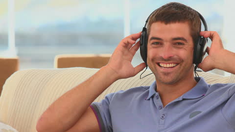 Smiling Man Relaxing with Headphones in Casual Setting