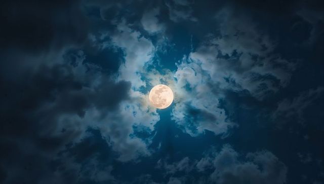 Serene full moon casts ethereal light over night sky