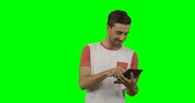 Man using tablet with green screen background suitable for digital content, website design, advertisements about technology or gadgets, and promoting e-learning material.
