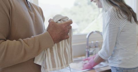 Middle-Aged Couple Doing Dishes Together in Cozy Kitchen
