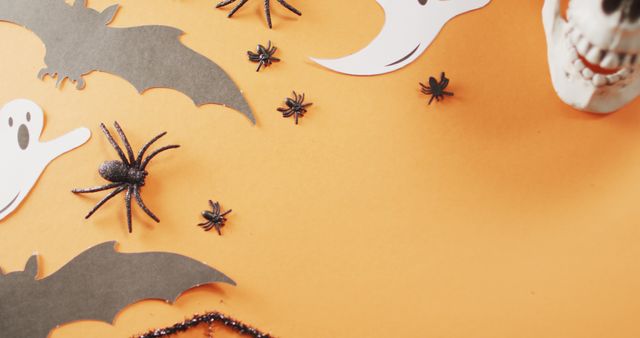 Decorative Halloween elements including black bats, spiders, ghosts, and a skull on vibrant orange backdrop create a festive atmosphere. Ideal for seasonal marketing, social media posts about Halloween, and DIY craft inspiration.