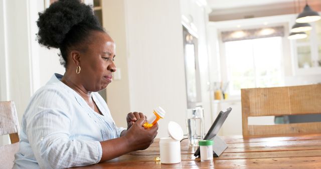 Senior Woman Taking Medication while Watching Digital Tablet - Download Free Stock Images Pikwizard.com