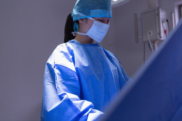 Front view of female surgeon performing operation in operation room at hospital