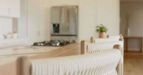 Scandinavian kitchen island with woven rope barstools, light-wood minimalist interior