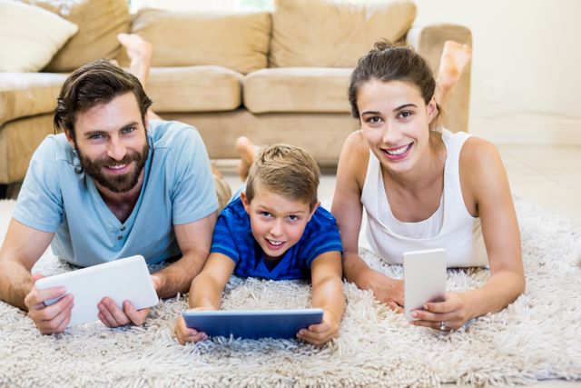 Portrait of parents and son using a laptop, tablet and phone at home