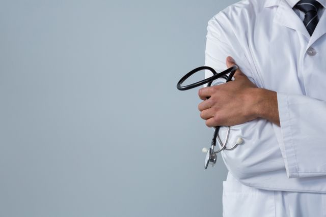 This image shows a doctor holding a stethoscope against a white background. It is ideal for use in healthcare-related content, medical websites, hospital brochures, and educational materials about the medical profession. The image conveys professionalism and the importance of healthcare services.