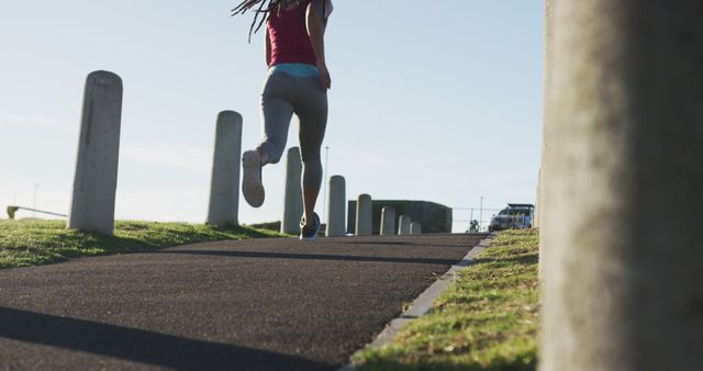 Woman running on pathway outdoors with sunlight and shadows - Download Free Stock Images Pikwizard.com