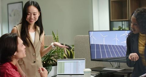 Diverse female coworkers collaborating on renewable energy software