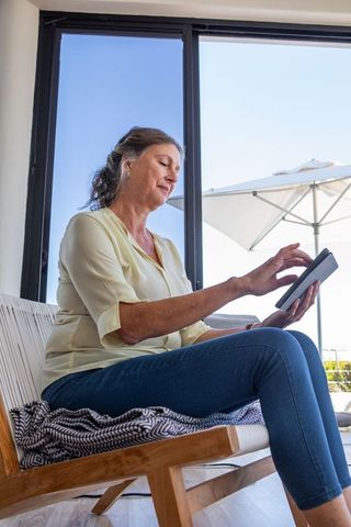 Senior Woman Relaxing with Tablet in Bright Modern Home