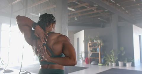 Strong Woman Demonstrating Stretching Technique in Contemporary Gym