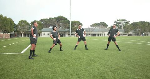Soccer Players Stretching on Field for Warm-Up