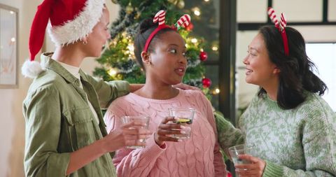 Diverse Friends Celebrating Christmas by Tree