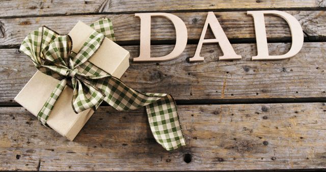 Gift Wrapped with Bow and Letters DAD on Wooden Background - Download Free Stock Images Pikwizard.com