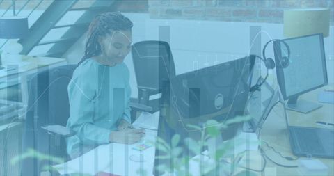 Businesswoman Analyzing Financial Data on Computer in Modern Office