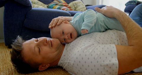 Father Embracing Infant in Tender Living Room Moment - Download Free Stock Images Pikwizard.com