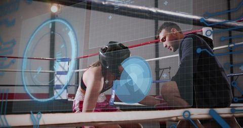 Female boxer receiving coach support with hud performance overlay in boxing ring