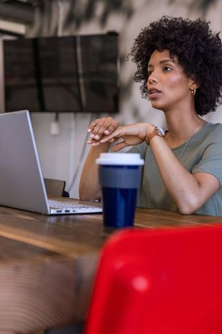 African American Professional Working on Laptop in Modern Meeting Room