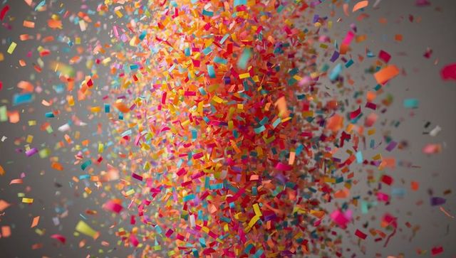Vibrant vertical cloud of colorful confetti drifting with motion blur and depth