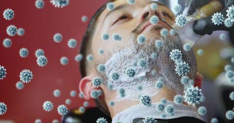 Barber shaving beard surrounded by conceptual virus particles