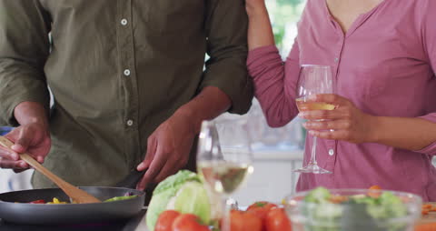 Couple Enjoying Cooking Together With Wine in Modern Kitchen