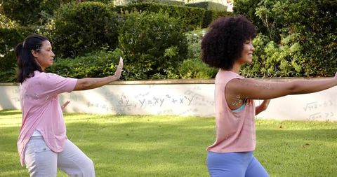 Two women practicing tai chi in garden with mathematical overlay, mindful movement and balance