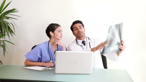 Medical Professionals Discussing X-Ray Results in Office