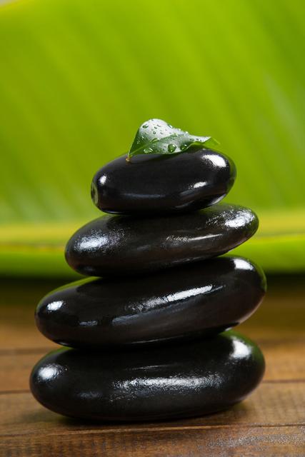 Stack of pebble stones with green leaf - Download Free Stock Photos Pikwizard.com
