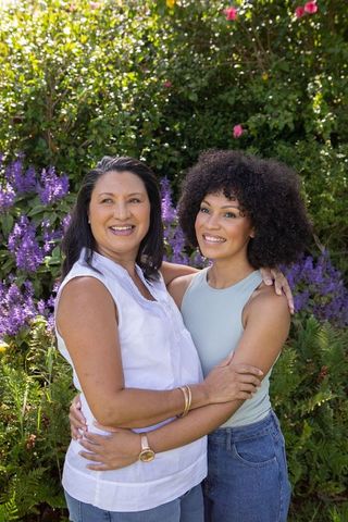 Mother and Daughter Embracing in Lush Garden Setting