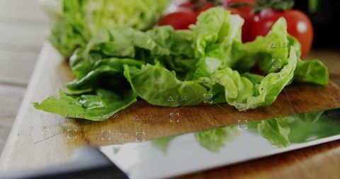 Macro fresh green lettuce on wooden cutting board with chef knife and cherry tomatoes