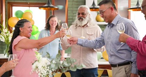Senior Multicultural Friends Celebrating Birthday with Toast and Cupcake