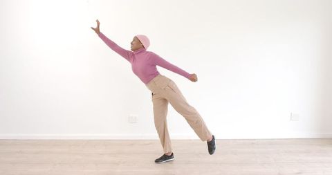 Confident woman strikes empowering pose in minimalist room