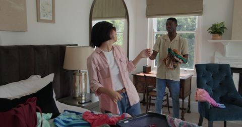 Couple Packing for Exciting Trip in Cozy Bedroom