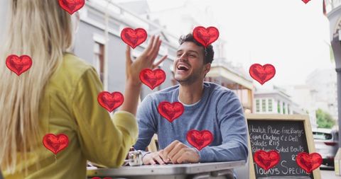 Couple enjoying outdoor date with heart overlays and happy smiles