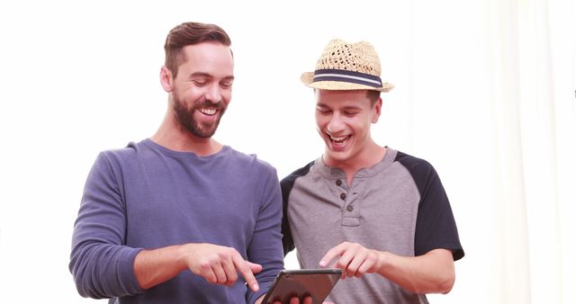 Two Happy Friends Using a Tablet Together - Download Free Stock Images Pikwizard.com