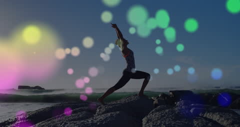 Yoga on Rocky Shore with Colorful Light Bokeh Effect