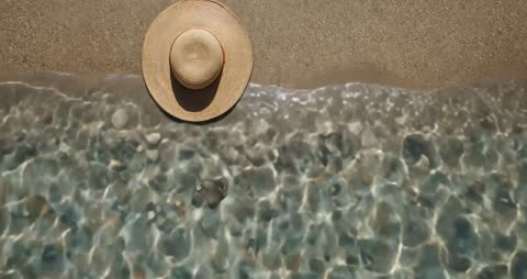 Tranquil Beach Scene with Straw Hat and Reflection
