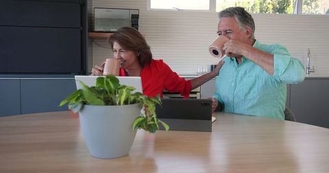 Senior Couple Celebrating Digital Success with Laptops
