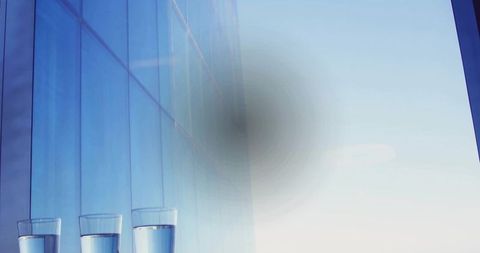 Minimalist Glasses on Reflective Ledge with Urban Background