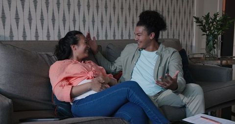 Smiling couple discussing wedding plans on couch