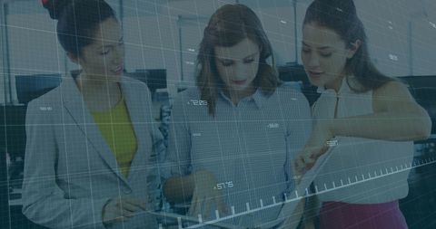 Businesswomen analyzing digital financial data in office