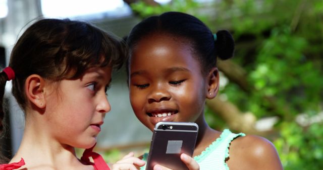 Diverse Young Girls Sharing and Playing with a Smartphone Outdoors - Download Free Stock Images Pikwizard.com