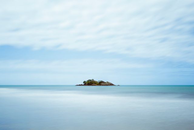 Remote Island in Calm Ocean on Cloudy Day with Serene Horizon - Download Free Stock Images Pikwizard.com