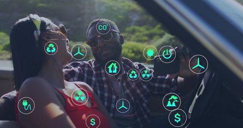 Couple taking selfie in convertible with eco icons overlay on sunny countryside drive
