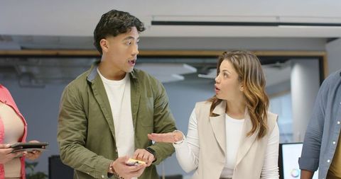 Diverse coworkers debating and gesturing in modern office collaboration scene