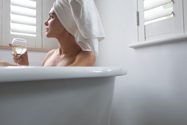This image can be used for promoting self-care routines, luxury bath products, spa services, or articles about relaxation and wellness. It portrays a serene moment of indulgence, ideal for advertising or editorial content emphasizing relaxation and leisure.