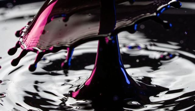 High-Speed Magenta and Blue Liquid Collision Creating Glossy Crown Splash and Reflective Ripples