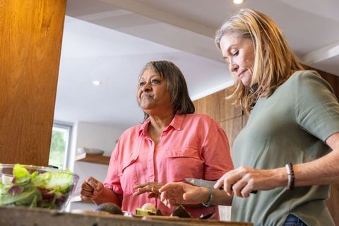Diverse women preparing avocado dish in modern kitchen