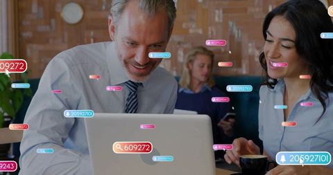 Coworkers collaborating over laptop in cafe with floating ui notifications and analytics